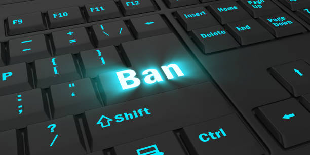 istock blue glowing Ban key on black keyboard 1087847528