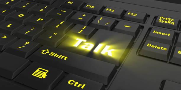 istock yellow glowing Talk key on black keyboard 1087854980