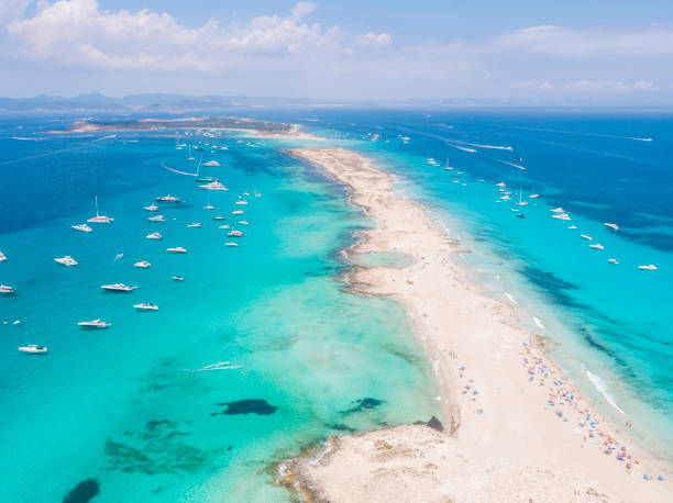 Formentera aerial view of turquoise water and yachts anchored Aerial overhead view of large amount of yachts anchored off the coast of Formentera Ibiza, with turquoise Mediterranean Sea and ocean blue water. anchored photos stock pictures, royalty-free photos & images