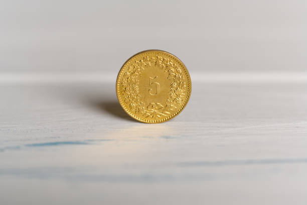 eine schweizer 5 cent-münze stehend auf einem hölzernen hintergrund - swiss currency swiss francs currency swiss coin stock-fotos und bilder