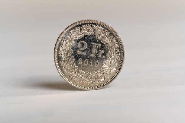 a 2 franc suisse de pièce debout sur un fond en bois - swiss currency coin swiss francs swiss coin photos et images de collection