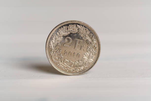2 franken münze schweizer stehen auf einem hölzernen hintergrund - swiss currency swiss francs currency swiss coin stock-fotos und bilder