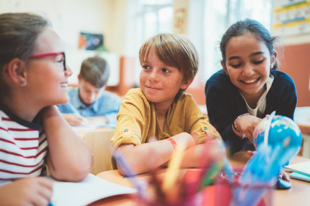 школьники наслаждаются уроком географии - elementary student classroom education elementary school building стоковые фото и изображения