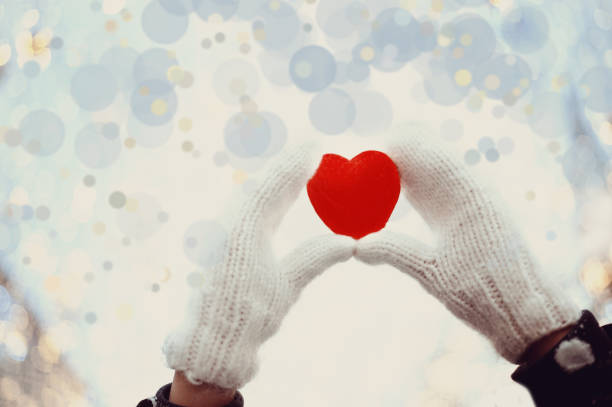 istock Red heart in woman's hands wearing white woolen mittens. Valentine's Day concept 1087873502