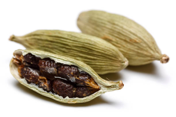 istock Green cardamom pods and seeds on white background 1087876494