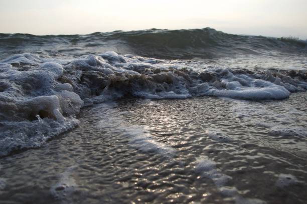 istock Close up of waves on a beach in the evening 1087886238
