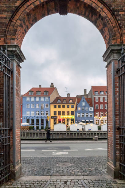 cornice in cornice di nyhavn con un turista che cammina a copenaghen - nyhavn canal foto e immagini stock