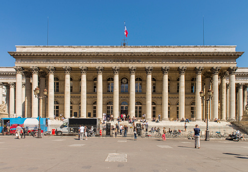 People walking next to the Bourse du Paris building (Paris Stock Exchange), know as Palais Brongniart, at Paris city, France.