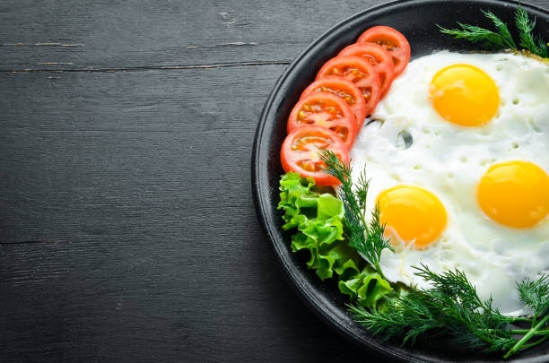 istock Eggs with tomatoes and fresh vegetables. Breakfast. Top view. Free space for your text. 1087906122