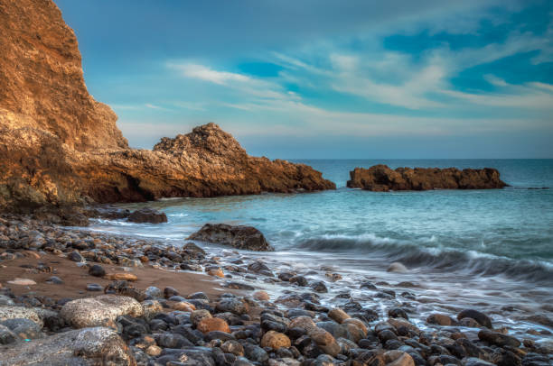 Sunset at Terranea Beach Long exposure of smooth waves crashing onto shore and water trickling through rocks on Terranea Beach at sunset, Rancho Palos Verdes, California rancho palos verdes stock pictures, royalty-free photos & images