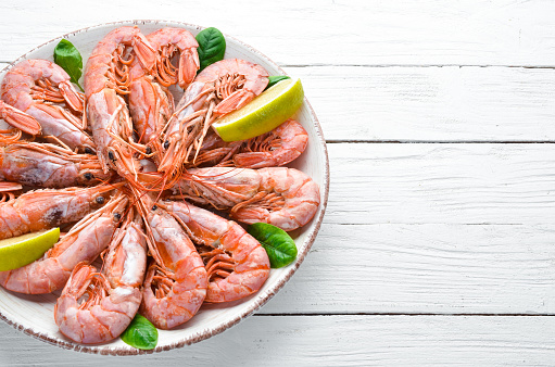 Great Royal Shrimps in a plate. Tiger prawns. Top view. Free space for your text. On the old background.