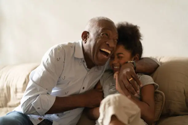 Photo of Grandfather Playing with Her Granddaughter at Home