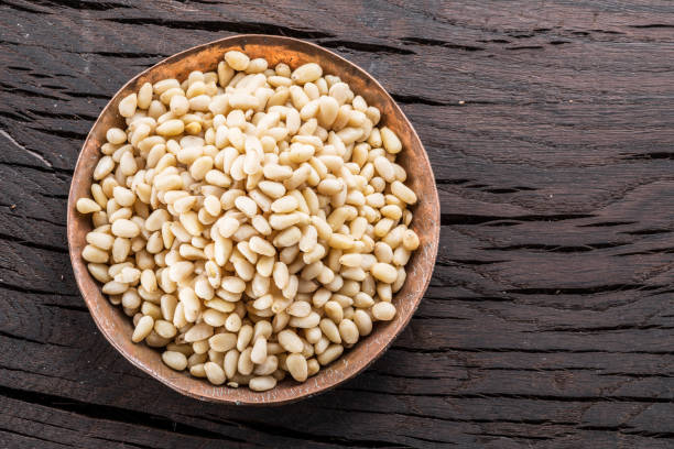 istock Pine nuts in the bowl on the wooden table. 1087915820