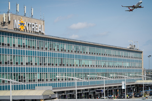 A view from a passenger window of a landed commercial flight taxiing around the airport of Schiphol in Amsterdam, the Netherlands. Architecture of the airport terminal buildings can be seen along with parked commercial flights at boarding gates