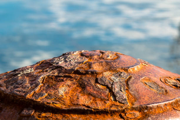 Old rusty metal corroded pier bollard on a sea shore