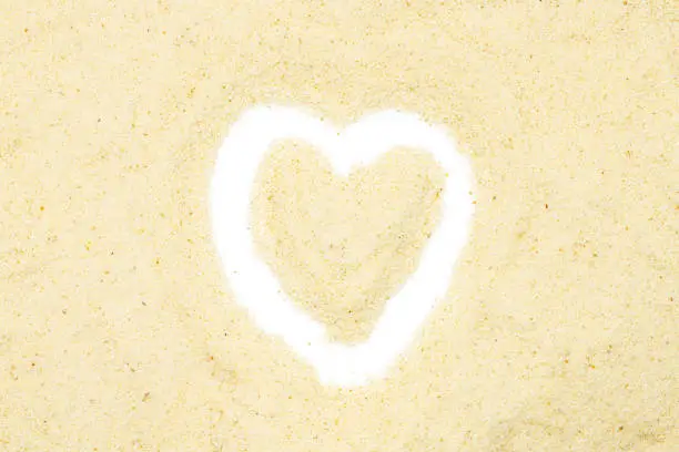 Photo of Semolina, heart-shaped, isolated, close up, macro, top view. Popular flour in cooking. Used for making of pasta or couscous or as baby food.