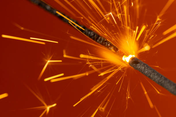 istock Flaming sparkler on red background close up macro 1087947538