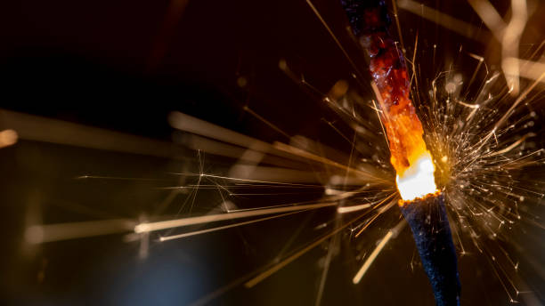 istock Flaming sparkler on red background close up macro 1087947546