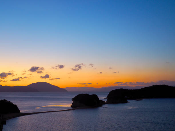 トップ サイドビュー視点から小豆島エンジェル ロードのシルエットの日の出 - 香川 ストックフォトと画像