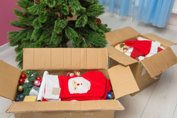 istock Boxes with Christmas decorations in front of an artificial Christmas tree 1087956478