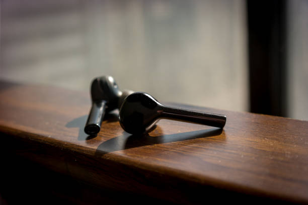 istock wireless black earbuds on a wooden texture 1087960854