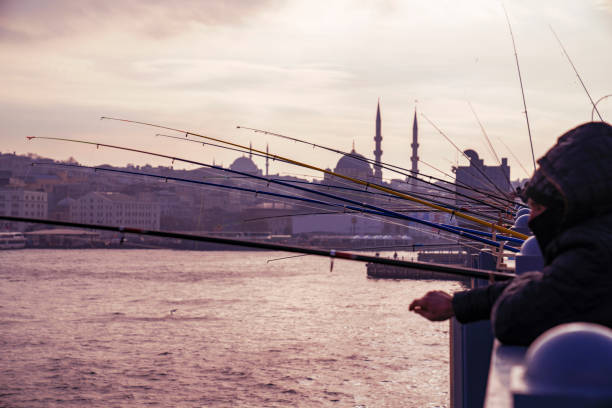 Istanbul, Turkey - December 22, 2018:Men fishing on Galata Bridge which spans the Golden Horn in Istanbul, Turkey.