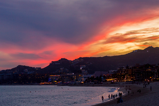 This is a view of the bay near Cabo San Lucas during a beautiful winter sunset.  Visible are the lights of the city as well as the sandy beaches that surround the bay.