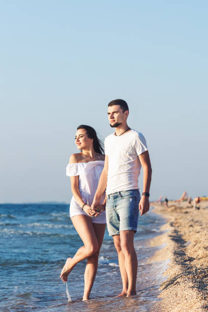 istock Young happy couple posing by the sea. 1087976740