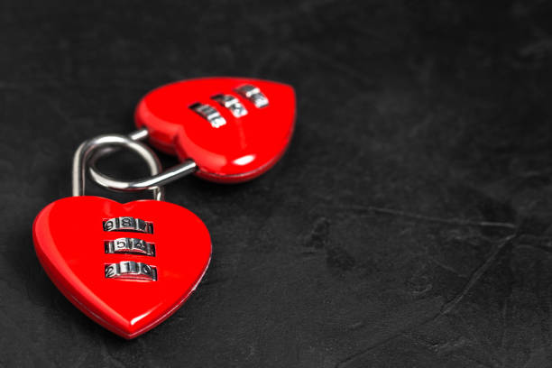 istock Valentine's Day background. Two red heart shape locks with copy space on black texture background 1087976772