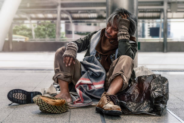 istock poor homeless beggar sitting on pathway in suffering manner 1088002312