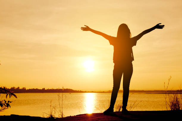istock silhouette woman relaxing in summer sunset sky 1088002478