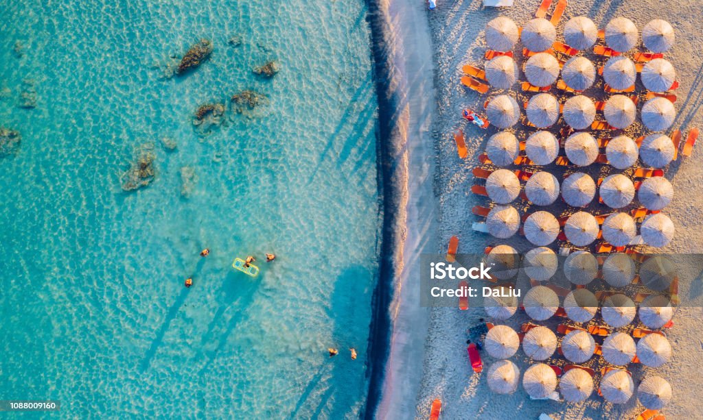 Aerial view of beautiful tropical Elafonissi Beach with pink sand. View of a nice tropical beach from the air. Beautiful sky, sea, resort. Seascape: Ocean and beautiful beach paradise. Elafonissi beach, Crete, Greece. Crete Stock Photo