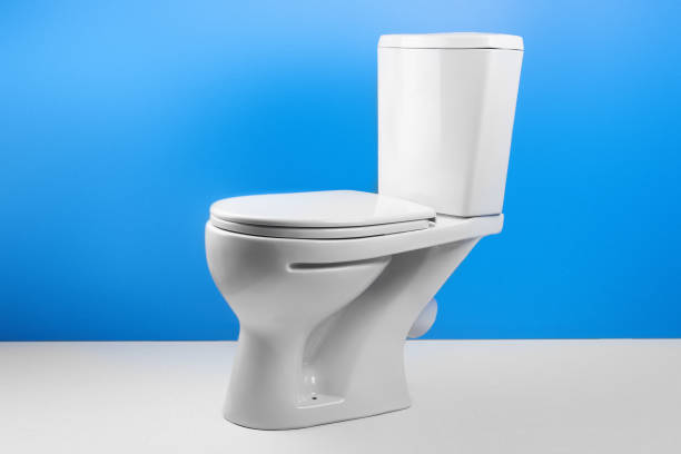 istock White toilet bowl on white blue background isolated. Side view 1088030604