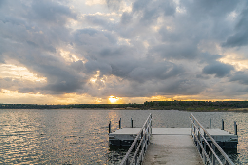 View of Metal Boat Dock with Sunset Behind Storm Clouds