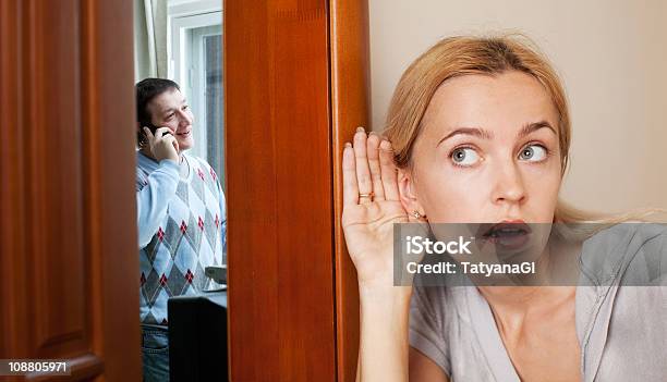 A Husband Unaware That His Wife Is Listening Nearby Stock Photo - Download Image Now