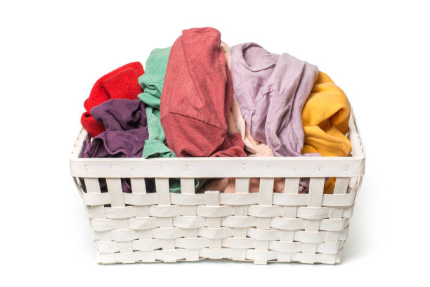 istock Clothes in a laundry wooden basket isolated on white background 1088065990