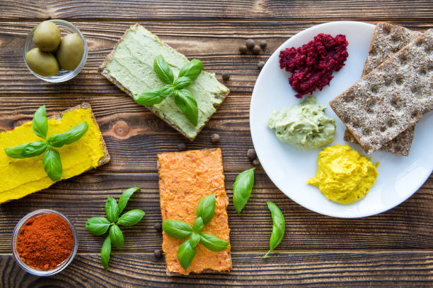 istock Assortment of hummus on white plate on brown table. 1088076064