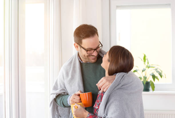 istock Couple covered with blanket and with hot tea beside window 1088082410