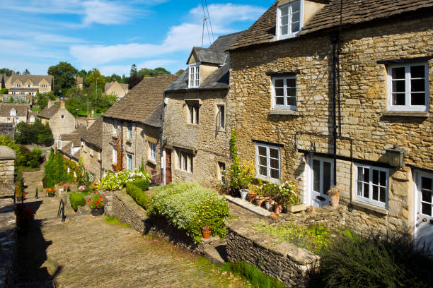 Picturesque old cottages line cobbled Chipping Steps in summer sunshine, Tetbury, Cotswolds, Gloucestershire, UK