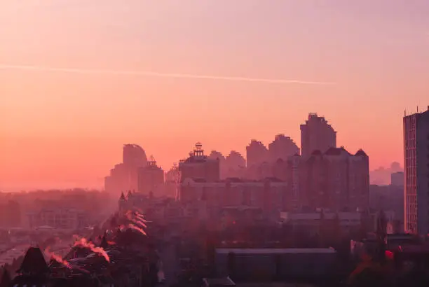 Photo of Beautiful early autumn morning sunrise over Kiev city. View at roofs of new Obolon enbankment prestigious modern district.
