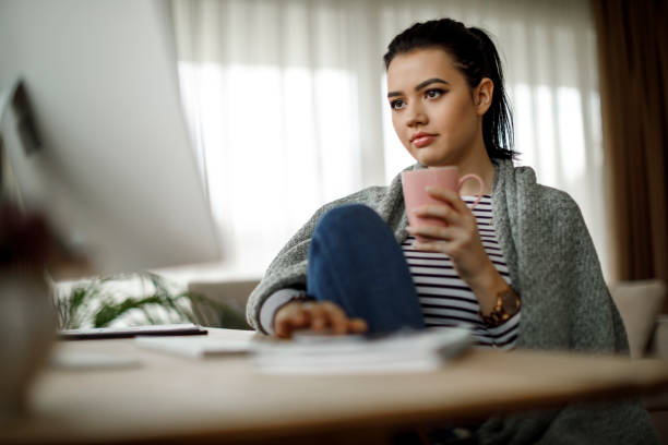 istock Charming girl wrapped in a blanket drinking morning coffee 1088105098