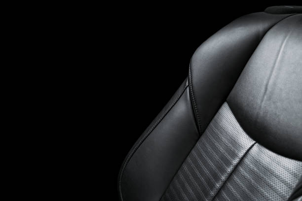 istock Black leather interior of a car. Perforated Leather comfortable seats with yellow stitching isolated on black background. Car interior details. Car detailing. Car inside 1088105674