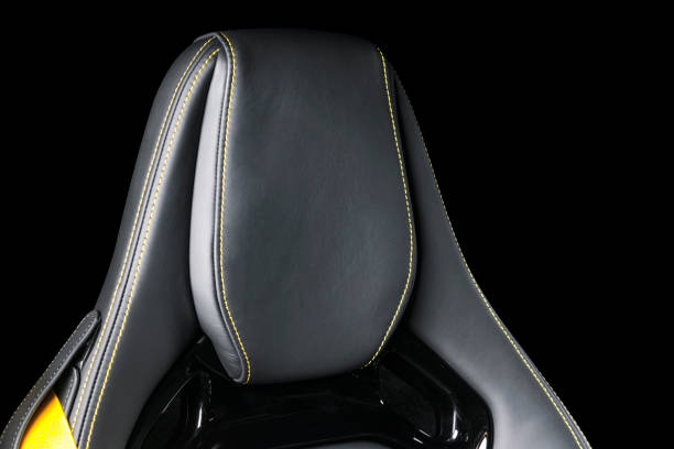 istock Black leather interior of a car. Perforated Leather comfortable seats with yellow stitching isolated on black background. Car interior details. Car detailing. Car inside 1088107454