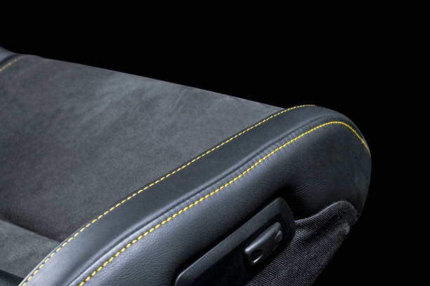 istock Black leather interior of a car. Perforated Leather comfortable seats with yellow stitching isolated on black background. Car interior details. Car detailing. Car inside 1088107592