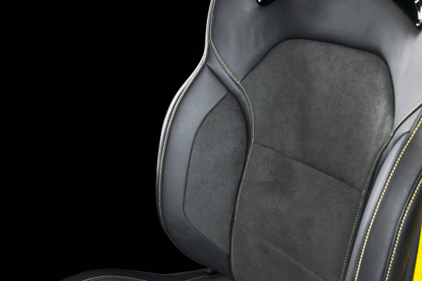 istock Black leather interior of a car. Perforated Leather comfortable seats with yellow stitching isolated on black background. Car interior details. Car detailing. Car inside 1088107912