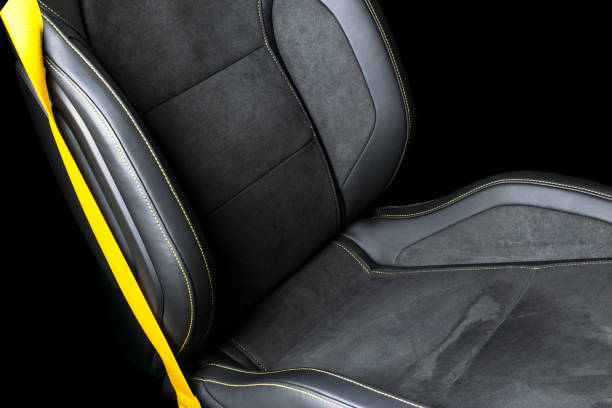 istock Black leather interior of a car. Perforated Leather comfortable seats with yellow stitching isolated on black background. Car interior details. Car detailing. Car inside 1088107976