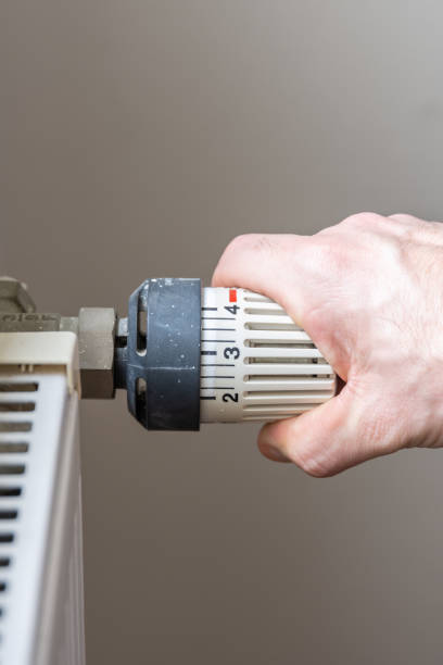 istock Male hand changing temperature on radiator. 1088120568