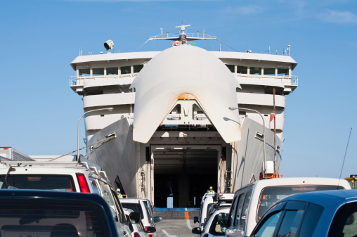 A ferry at the port ready for boarding of cars in the Sado island, Niigata, Japan. Front view of the ship which lifts the bow and opens the boarding gate.