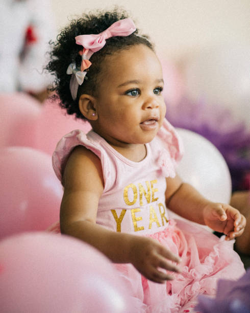 beautiful one year old baby girl, dressed in pink, celebrating her first birthday. - personal accessory balloon beauty birthday imagens e fotografias de stock