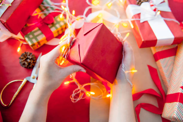 istock Female hands wrapping red christmas gift boxes 1088165470